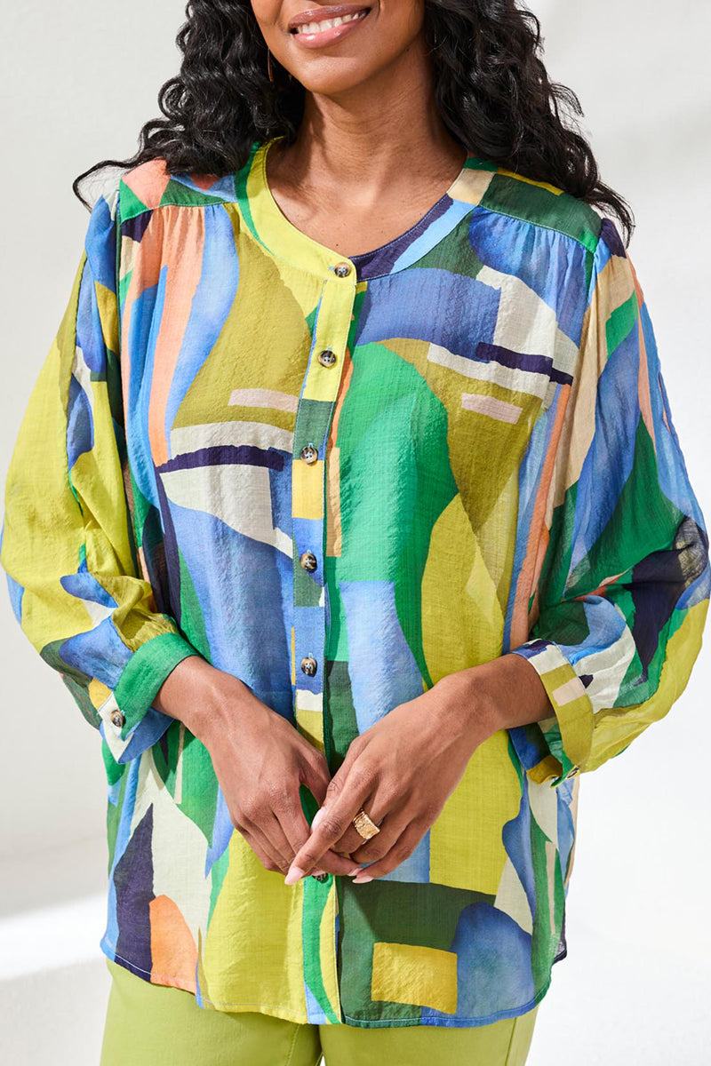 Woman wearing a colorful abstract patterned shirt against a white background