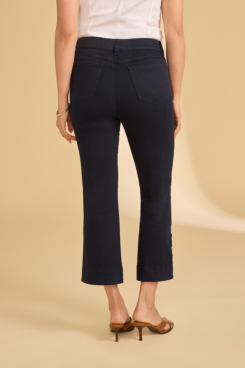 Person wearing navy pants on a beige background