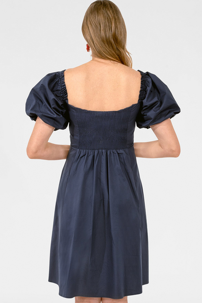 Navy blue dress with puff sleeves on a white background
