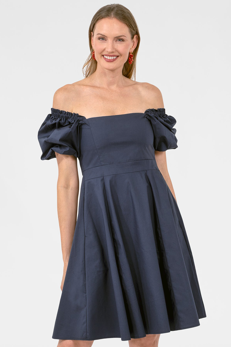Woman wearing a navy off-shoulder dress on a white background