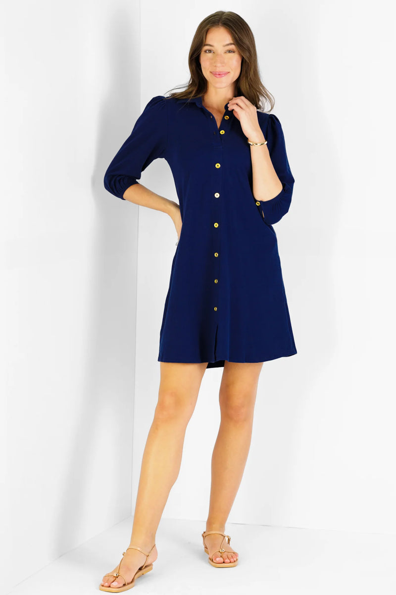 Woman wearing a navy blue dress with buttons on a white background
