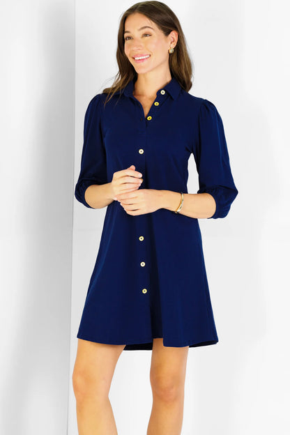 Woman wearing a navy blue dress with buttons on a white background