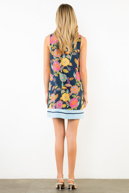 Woman wearing a sleeveless floral dress with a white background