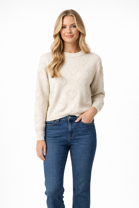 Woman wearing a cream sweater and blue jeans on a white background