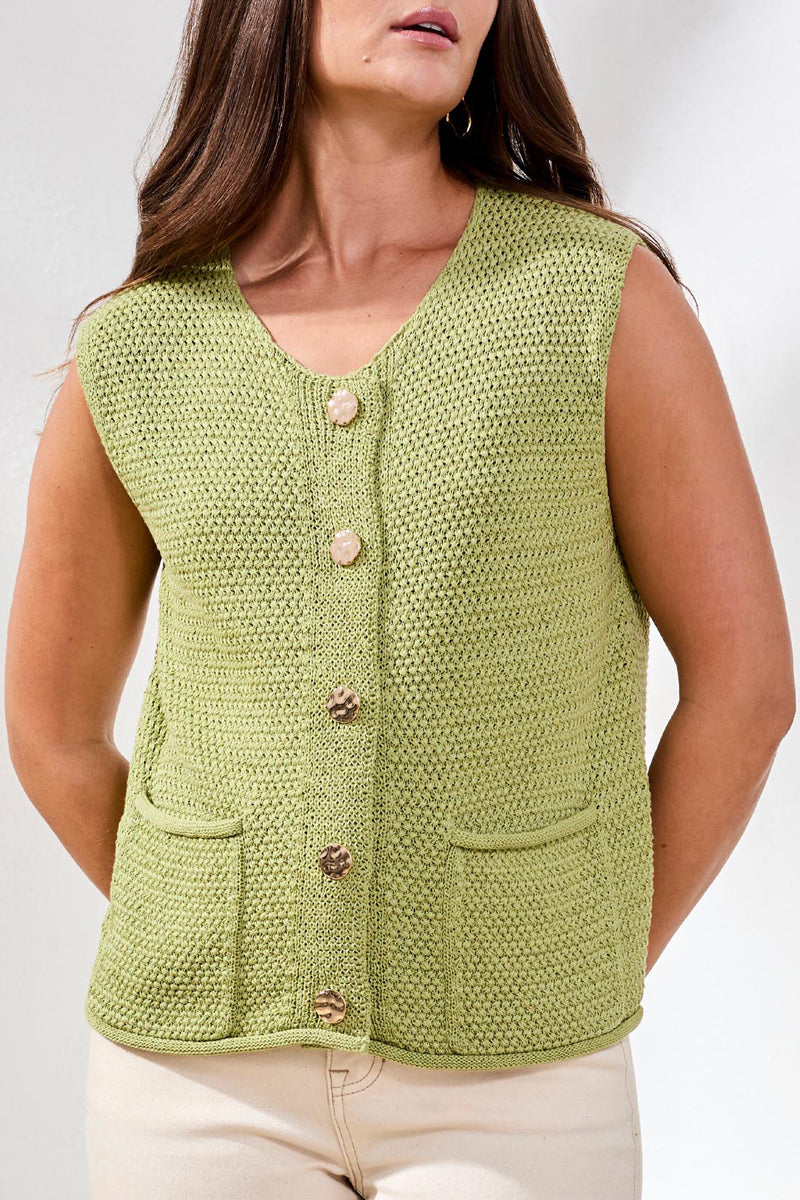 Woman wearing a green knitted vest with buttons on a white background