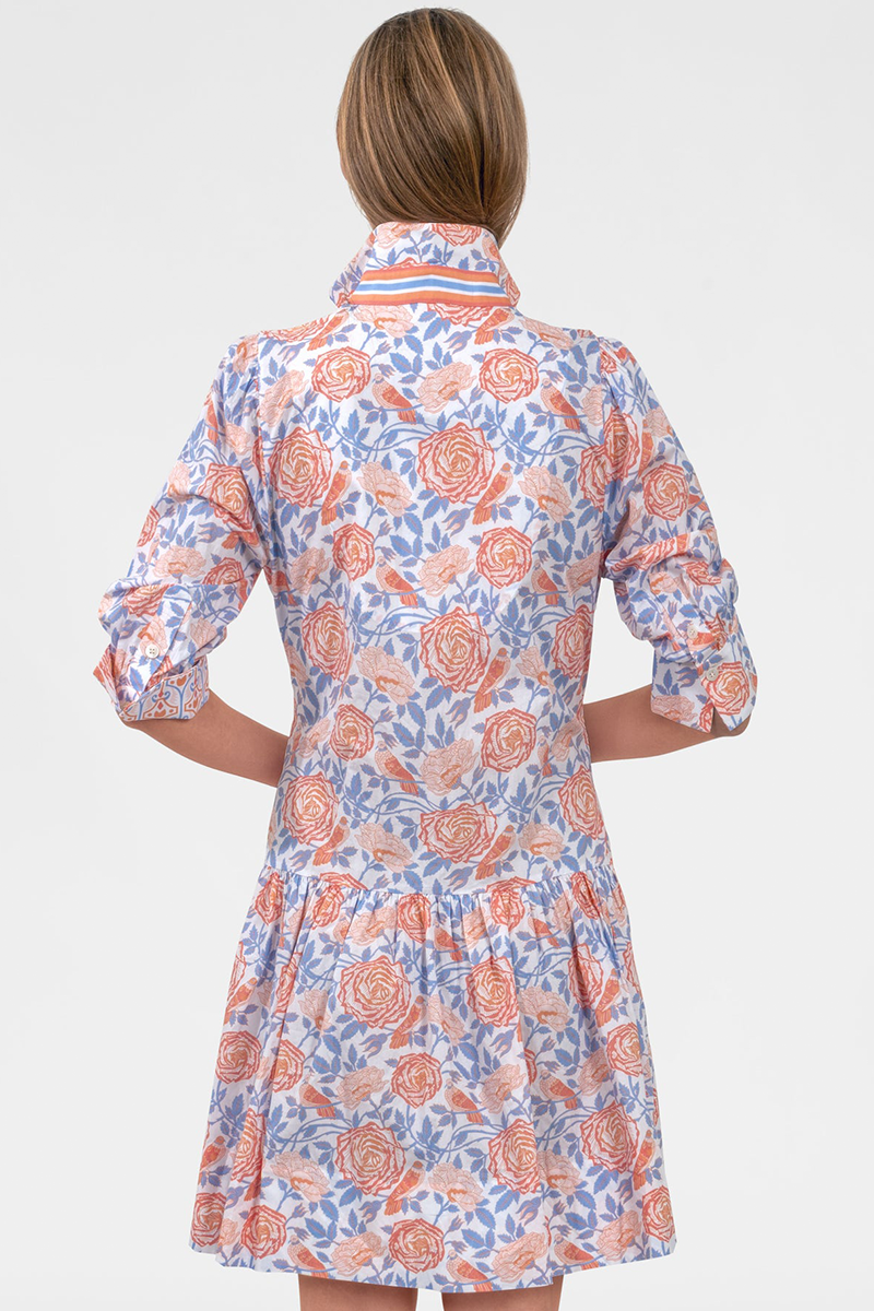Woman wearing a floral dress with orange and blue pattern on a white background