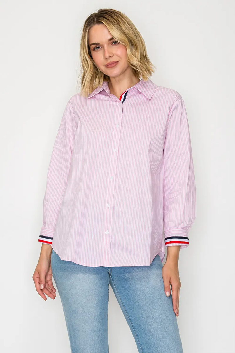 Woman wearing a pink striped shirt and blue jeans against a white background