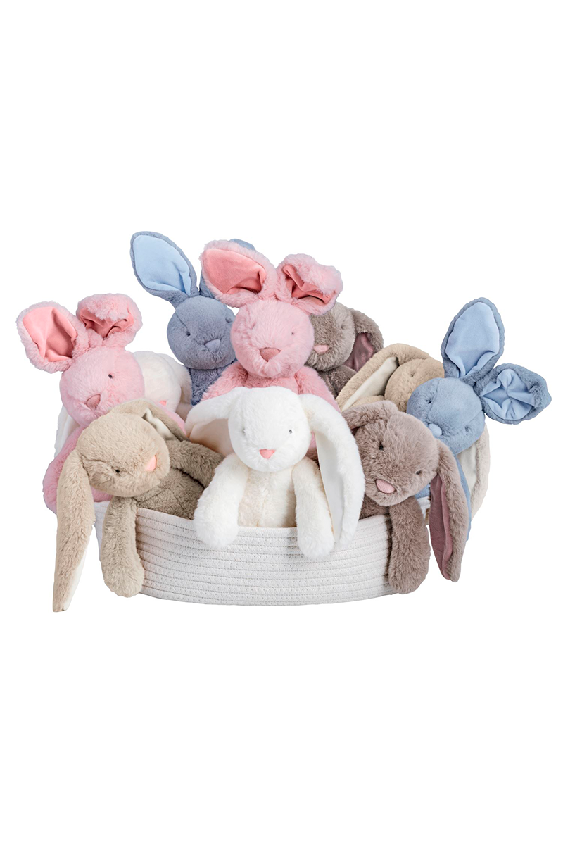 Basket of soft toy bunnies in various colors on a white background