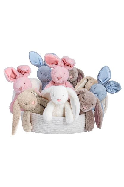 Basket of soft toy bunnies in various colors on a white background