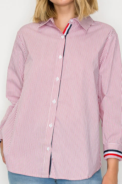 Person wearing a red and white striped shirt with a visible brand logo on a plain background