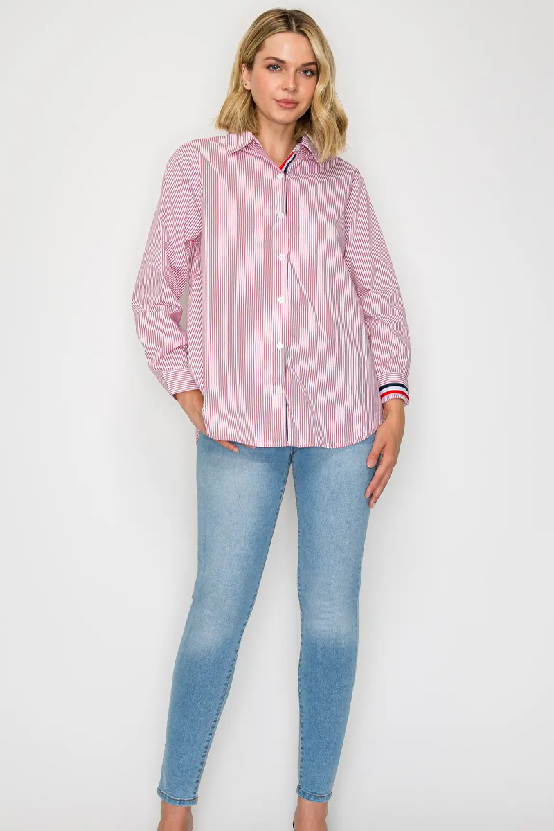 Woman wearing a pink striped shirt and blue jeans on a white background