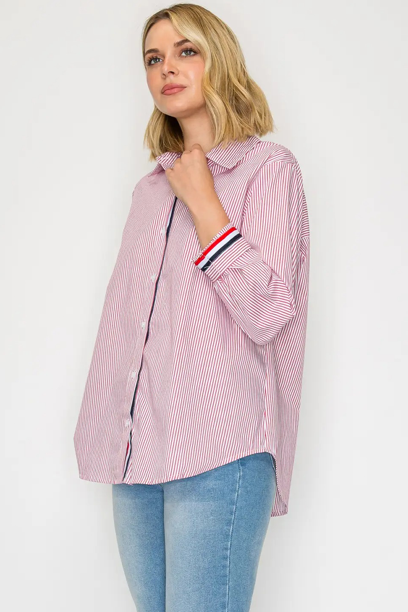 Woman wearing a pink and white striped shirt with rolled-up sleeves on a white background