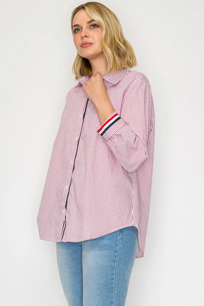 Woman wearing a pink and white striped shirt with rolled-up sleeves on a white background