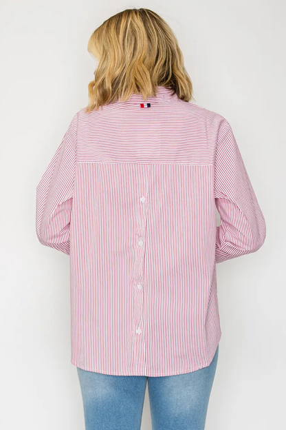 Person wearing a pink and white striped shirt with a visible brand logo on a white background