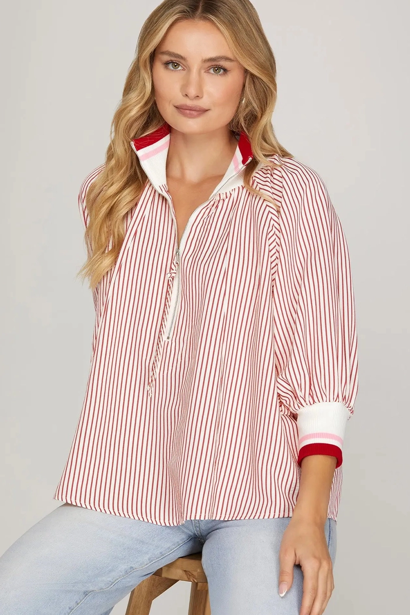 Woman wearing a red and white striped shirt with a collar on a gray background