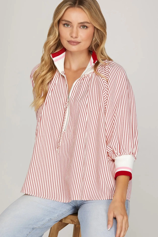 Woman wearing a red and white striped shirt with a collar on a gray background