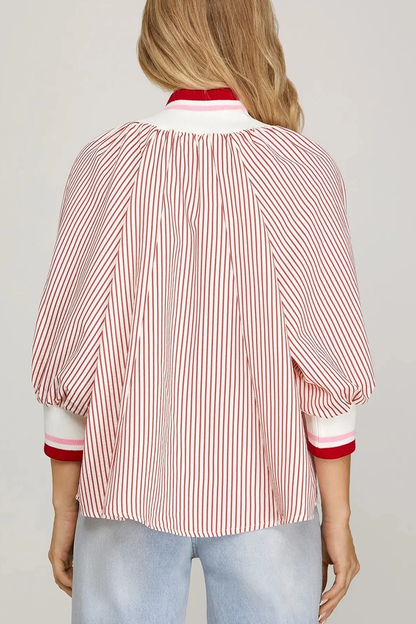 Woman wearing a red and white striped shirt with a plain background