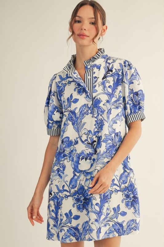 Woman wearing a blue floral dress with a white background