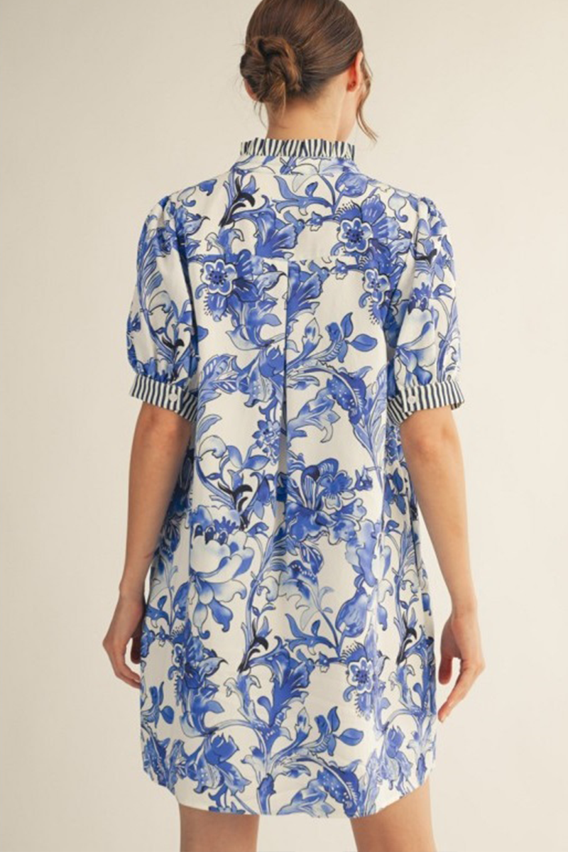 Woman wearing a blue and white floral dress on a beige background
