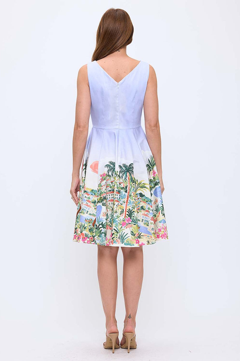 Woman wearing a light blue dress with a colorful tropical print on a white background