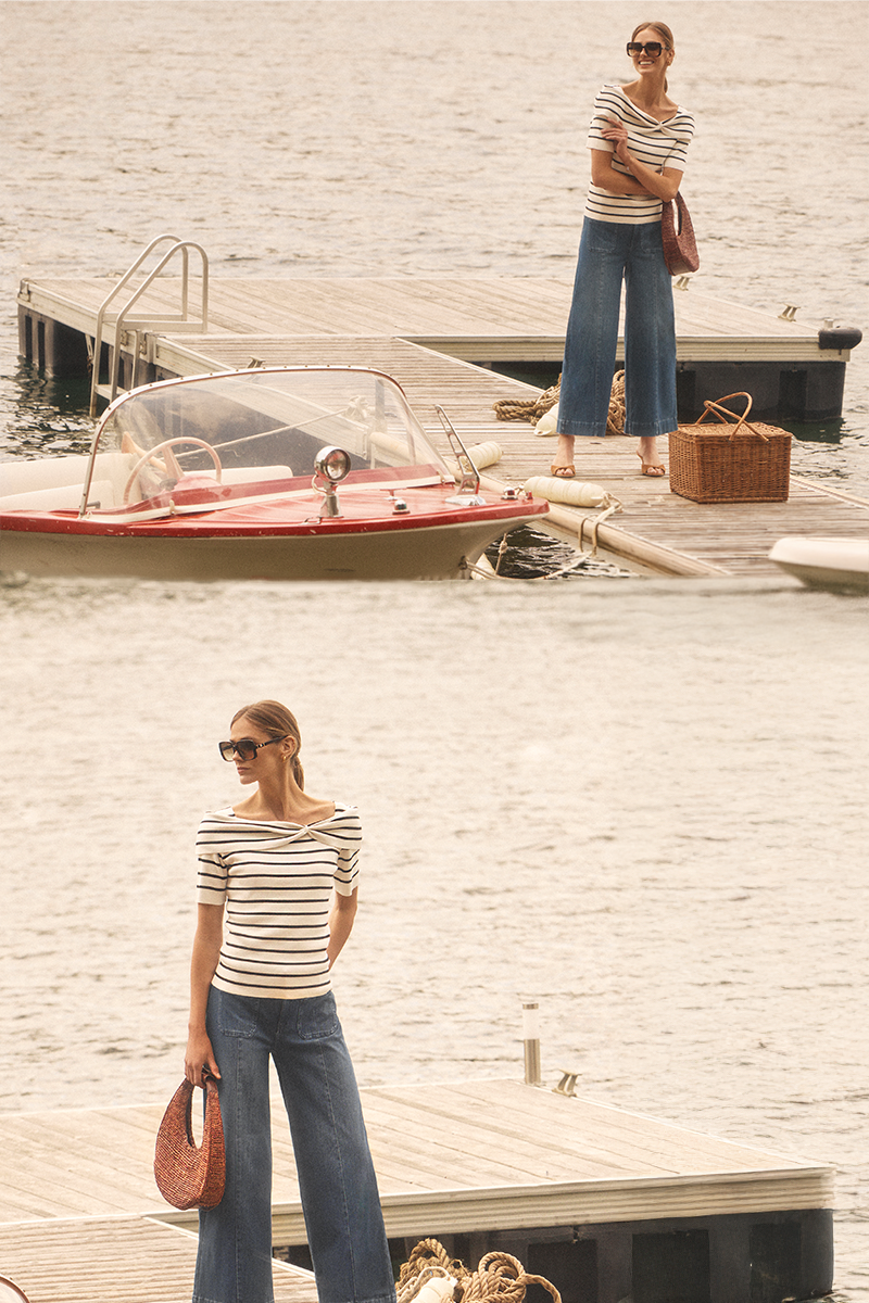 Two women on a dock by a boat, wearing striped shirts and jeans.