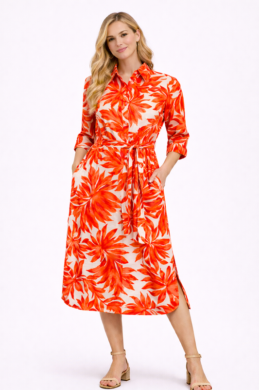 Woman wearing a red orange and white floral dress on a white background