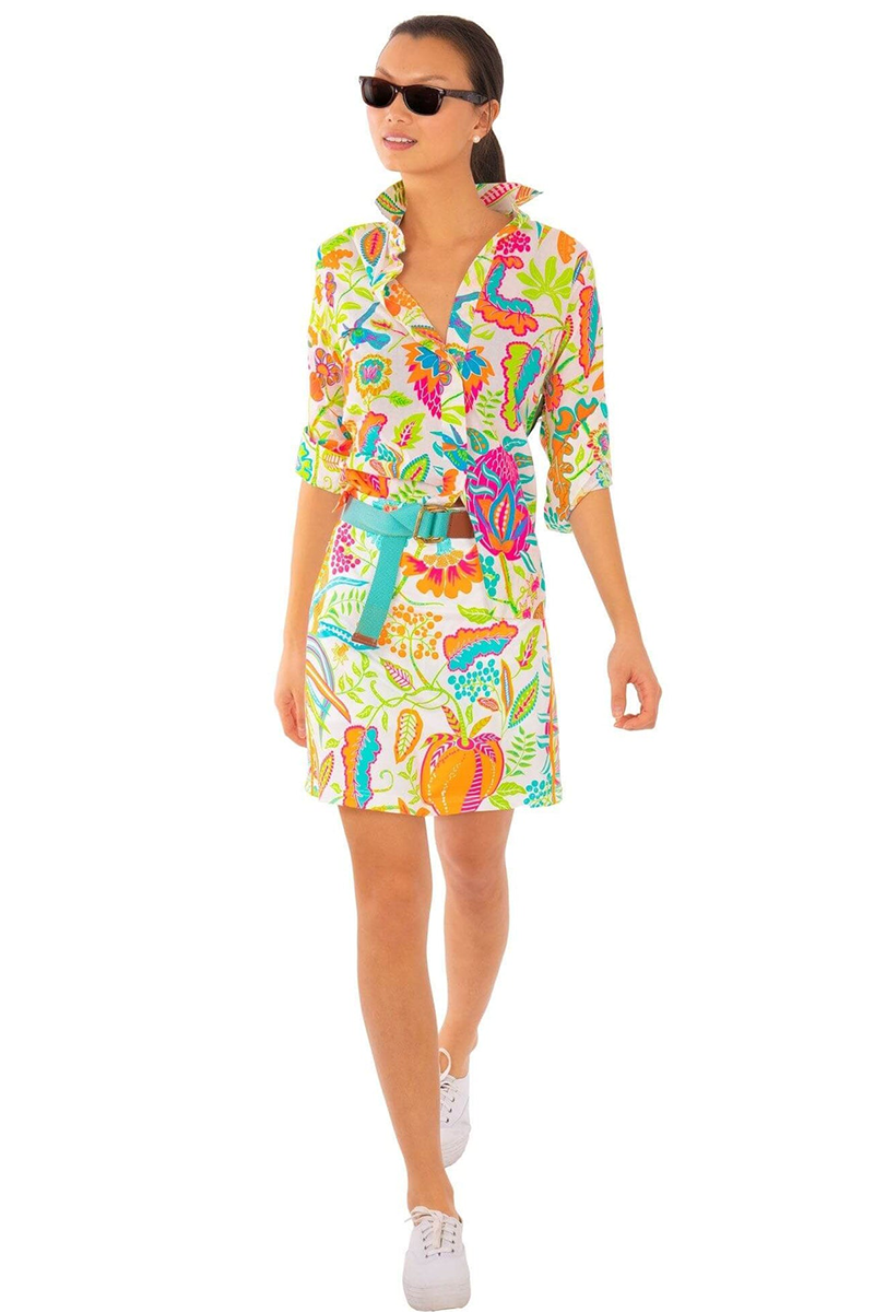 Woman wearing a colorful dress with turquoise belt a white background