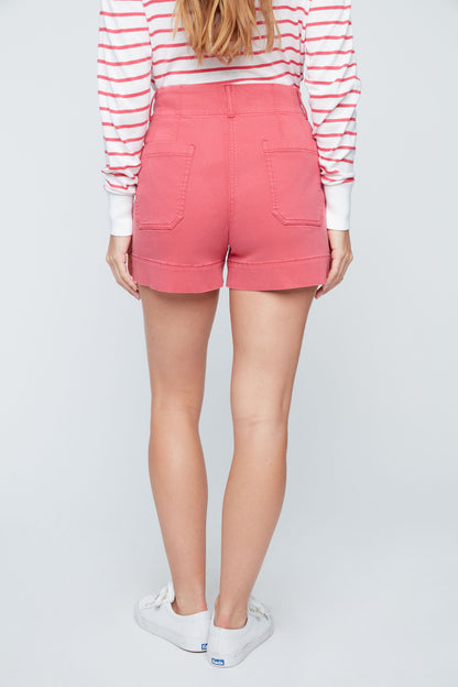 Person wearing pink shorts and a striped shirt on a white background