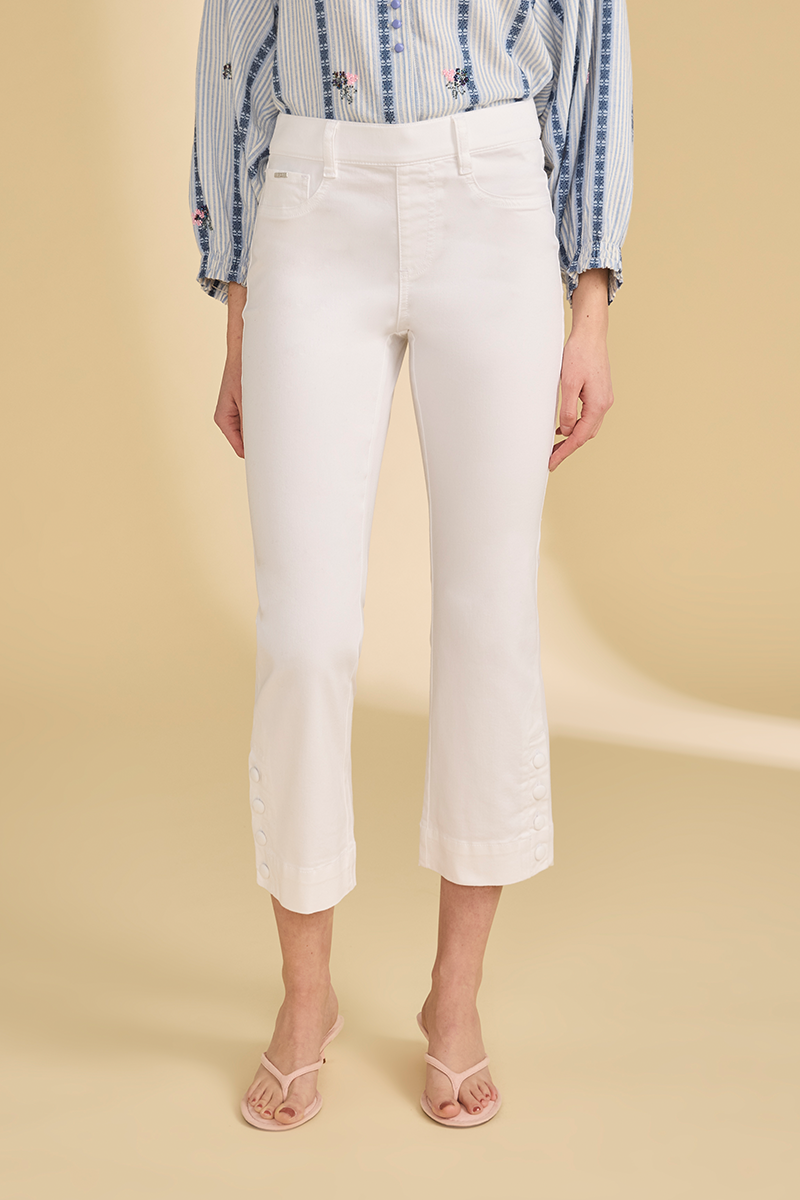 Person wearing white pants and a stripe shirt on a beige background