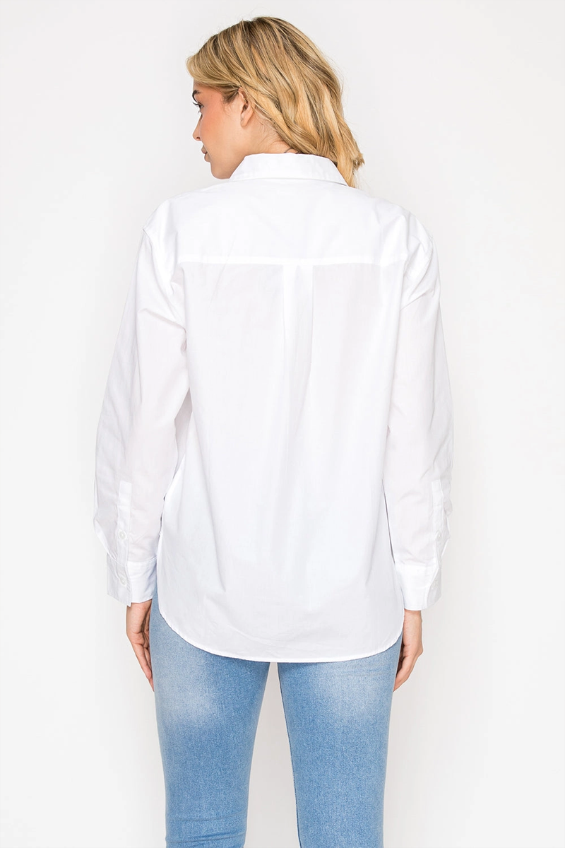 Woman wearing a white shirt and light blue jeans on a plain background