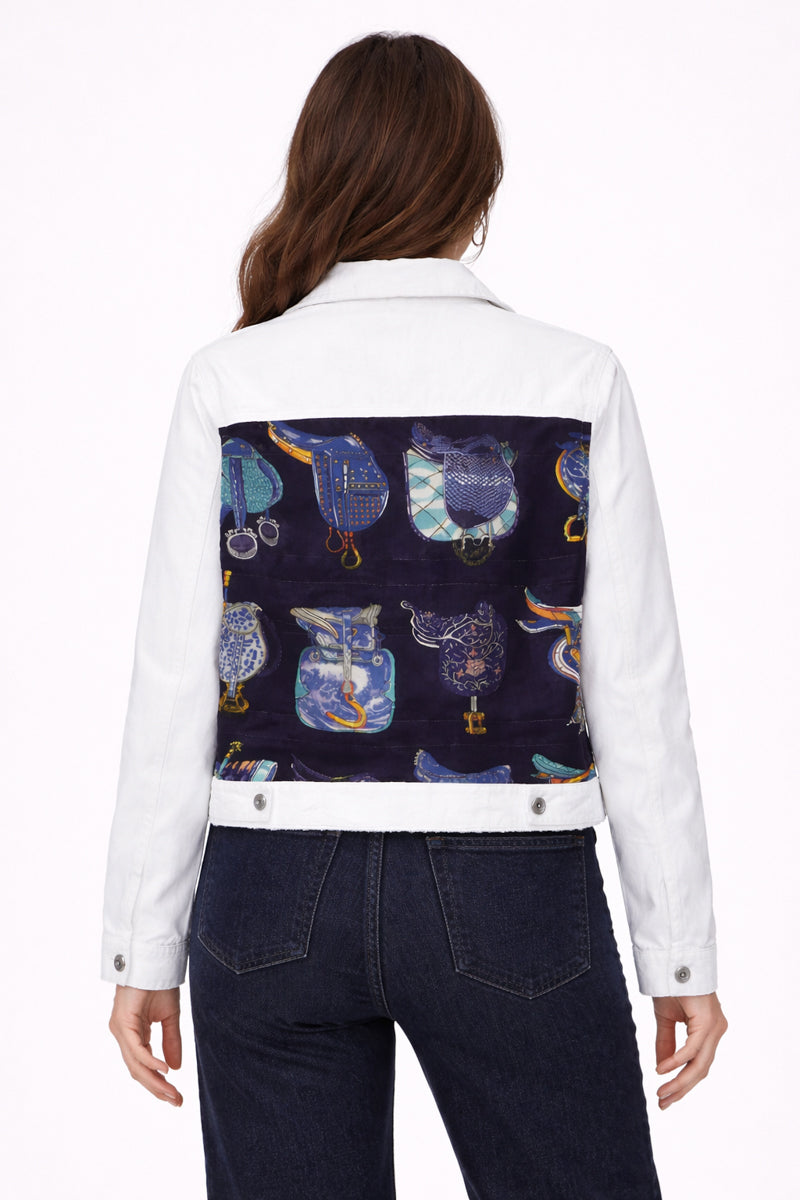 White denim jacket with a colorful owl pattern on the back, worn by a person.