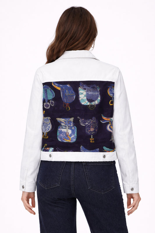 White denim jacket with a colorful owl pattern on the back, worn by a person.