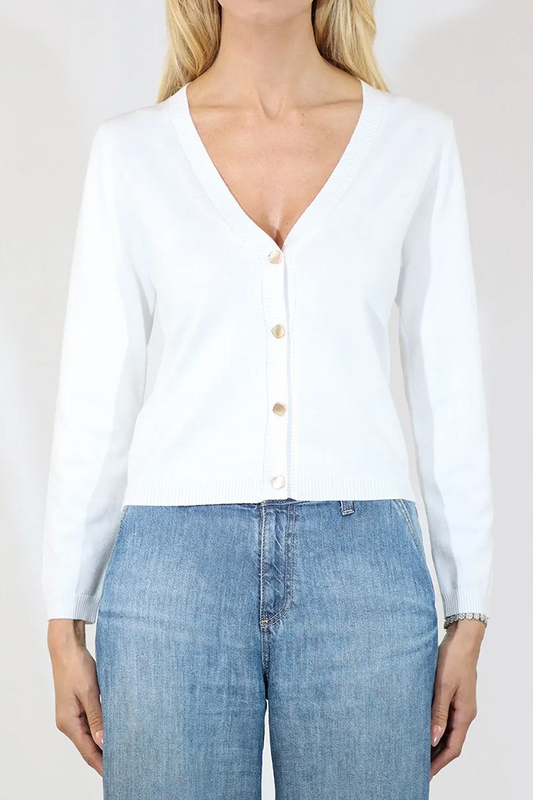 Person wearing a white button-up shirt and blue jeans on a plain background