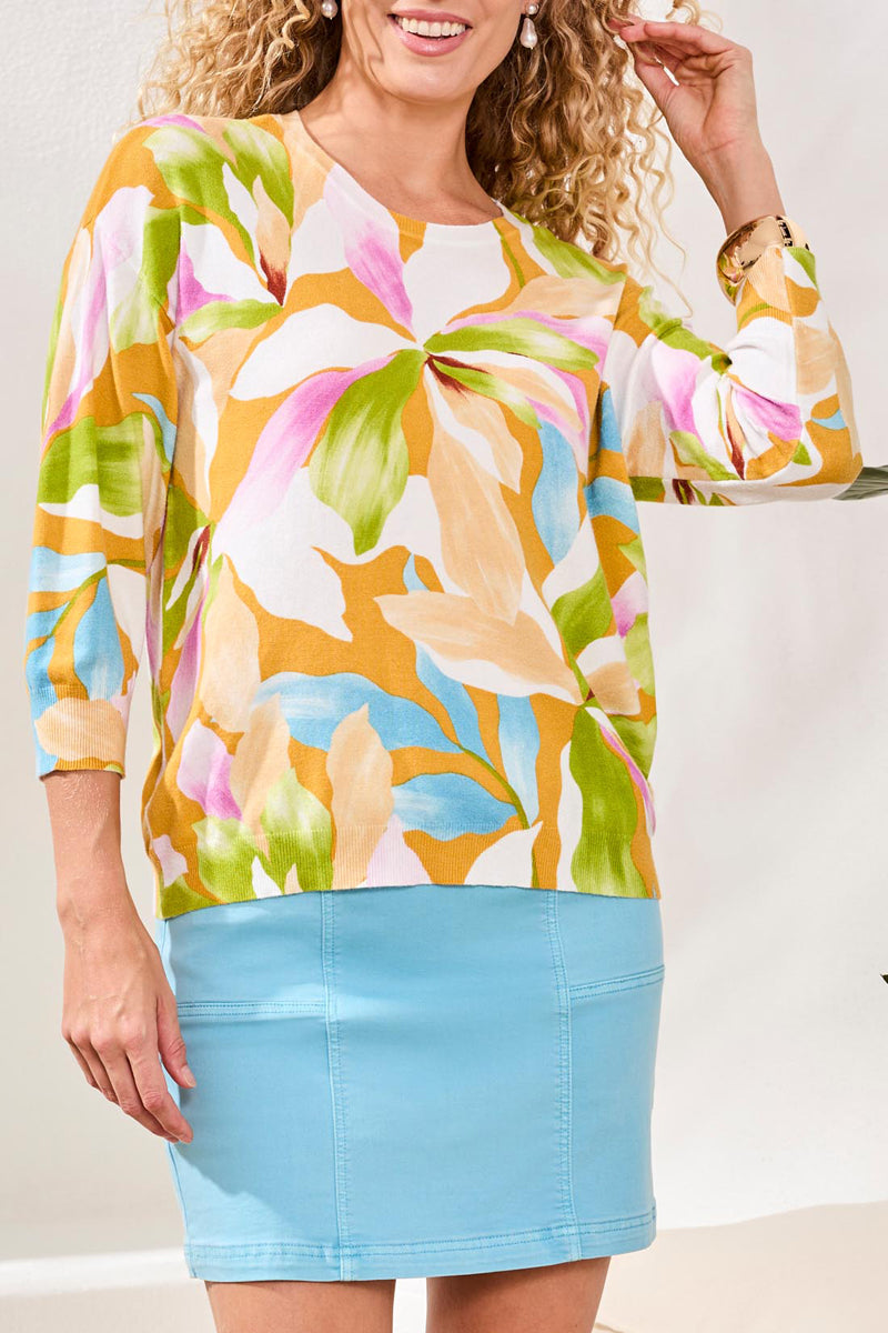 Woman wearing a colorful floral blouse and blue skirt on a white background