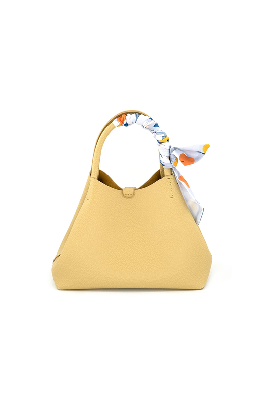 Yellow handbag with a colorful scarf on a white background