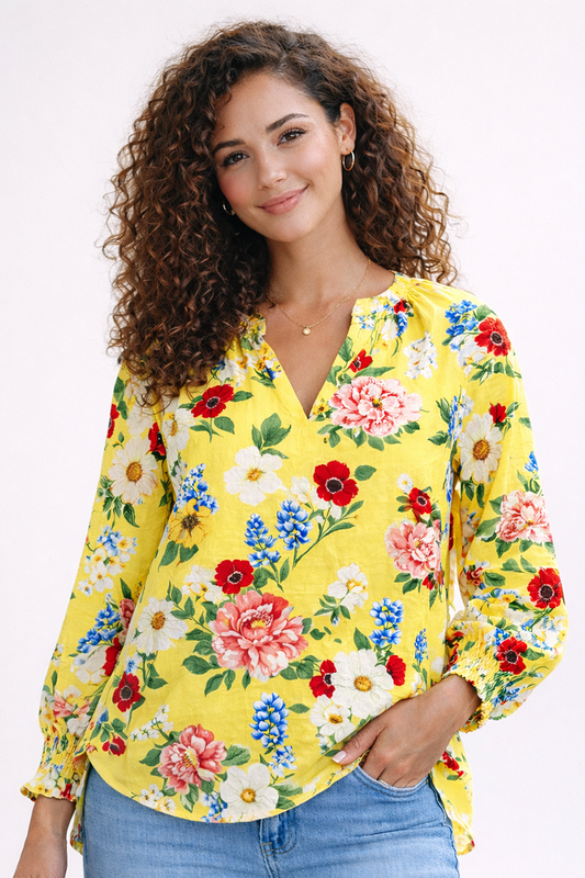 Woman wearing a yellow floral blouse against a white background